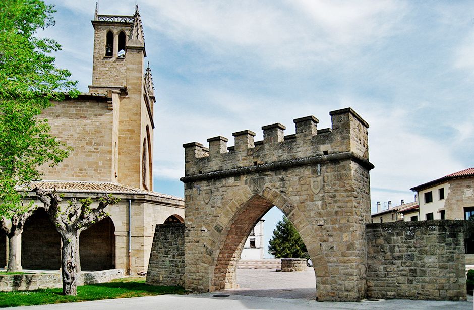 Vista exterior de la Villa de Obanos donde se observa la Iglesia de San Juan Bautista y la Puerta de piedra. 